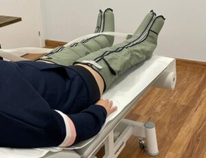Pacient a llitera amb botes de pressoteràpia