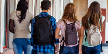 Grupo de adolescentes llegando al instituto con sus mochilas